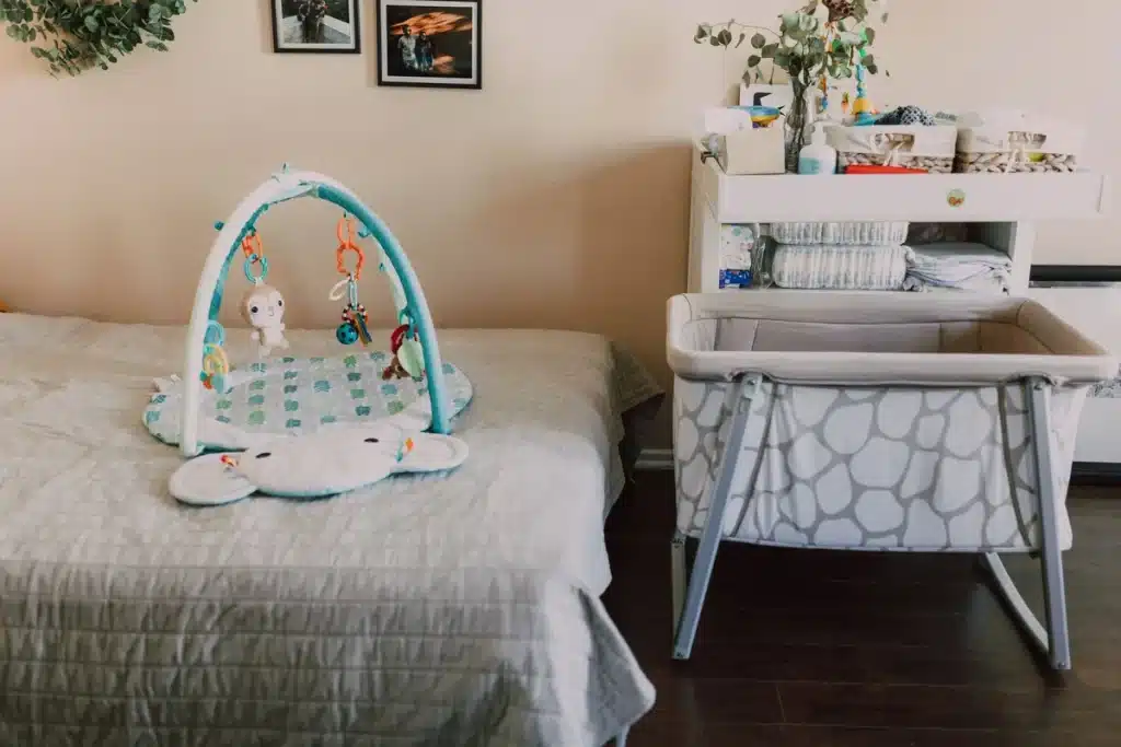 Chambre bébé aménagée avec lit, table à langer et rangements en bois clair dans des tons neutres