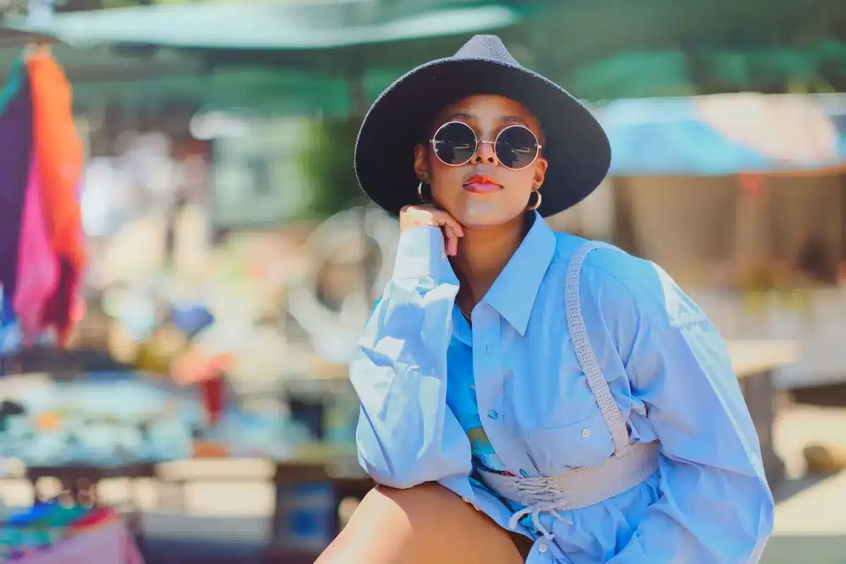 Femme au visage rond portant un chapeau fédora qui allonge les traits
