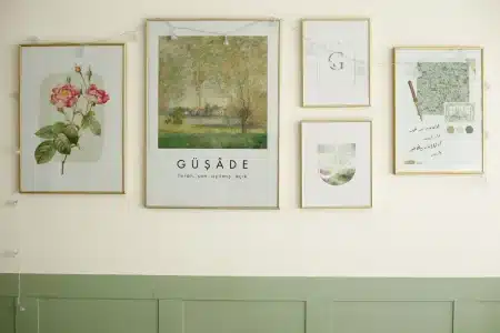 Silhouette d'une personne en vêtements minimalistes appuyée contre un mur blanc dans une galerie d'art