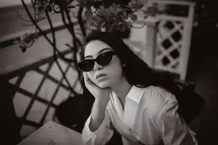 Femme portant des lunettes de soleil noires avec monture mi-rectangulaire en lumière naturelle d'été