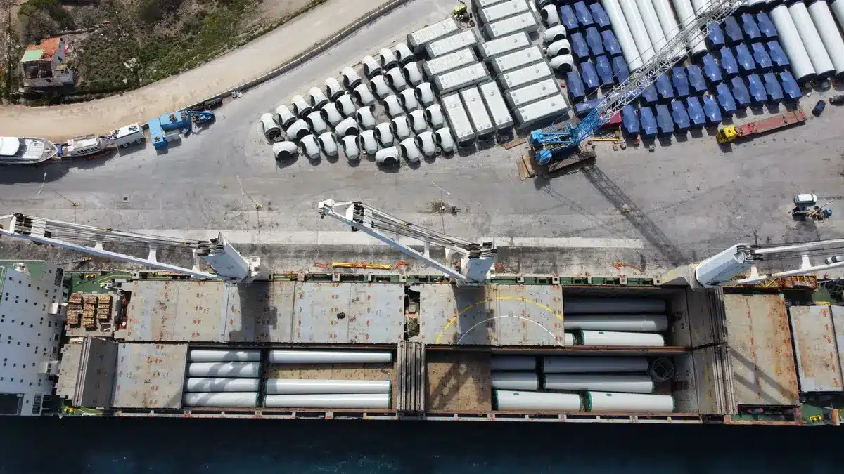 Composants géants d'éoliennes flottantes entreposés sur les quais d'un port industriel