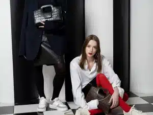 Sac à main noir compact en cuir avec poignée courte, porté avec jean et top noir