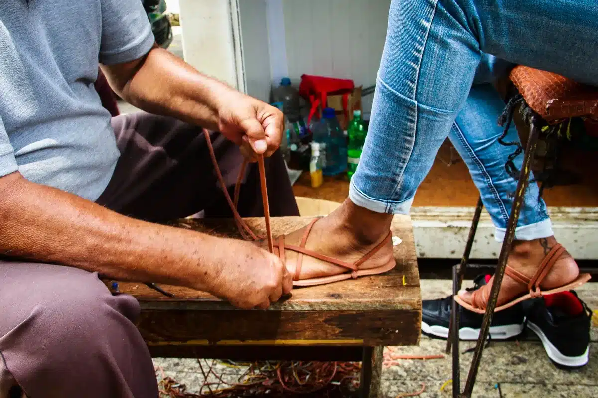 Détail de sandales artisanales en cuir fabriquées à la main, montrant les coutures régulières et la qualité des matériau