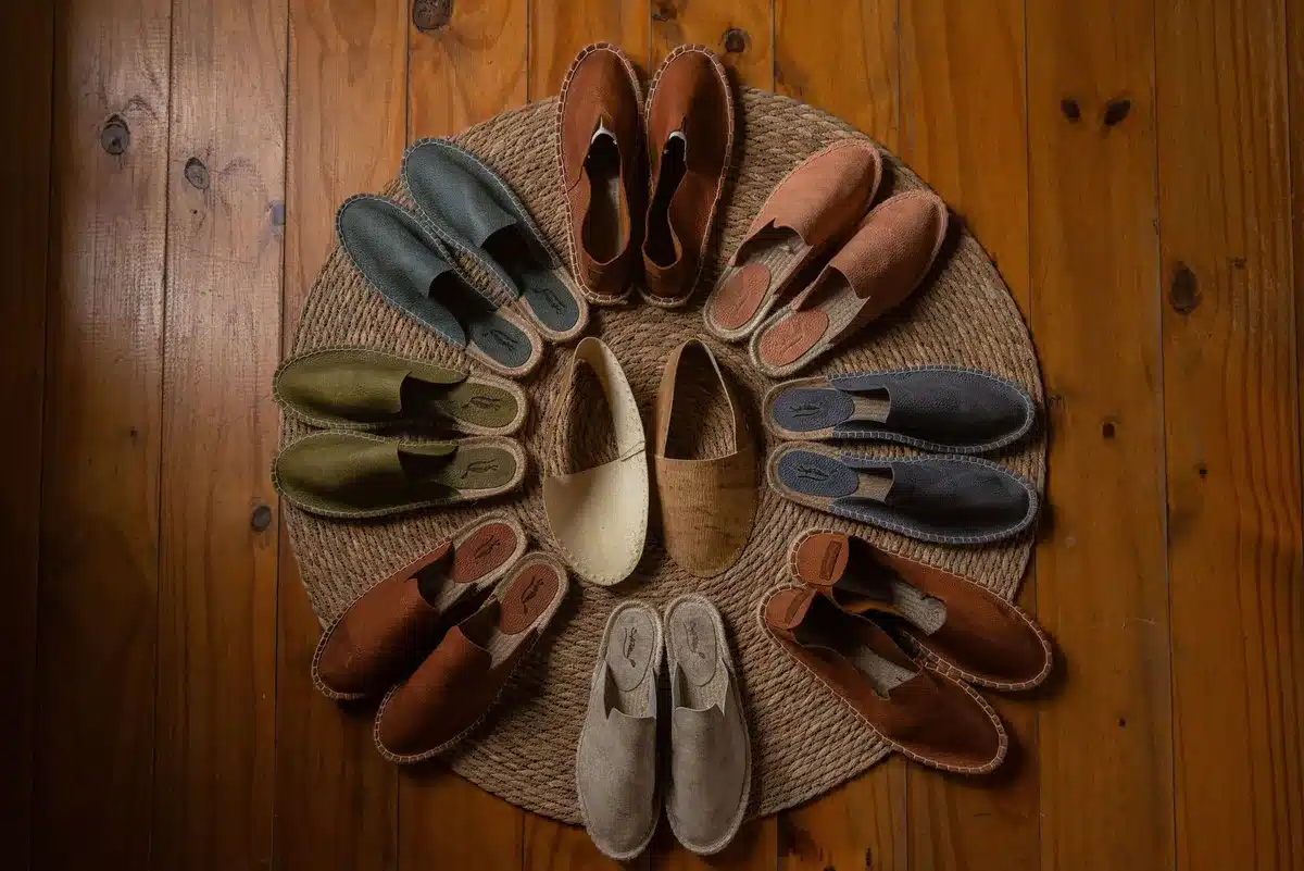 Paire de sandales estivales en cuir naturel posée sur un fond minimaliste, symbolisant la consommation durable
