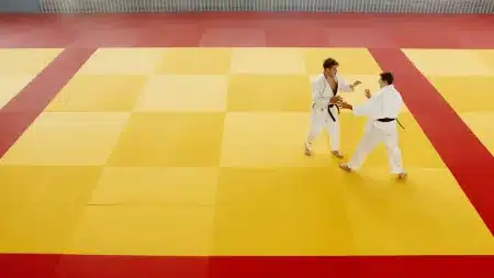 Deux judokas en combat sur un tatami lors d'une compétition internationale