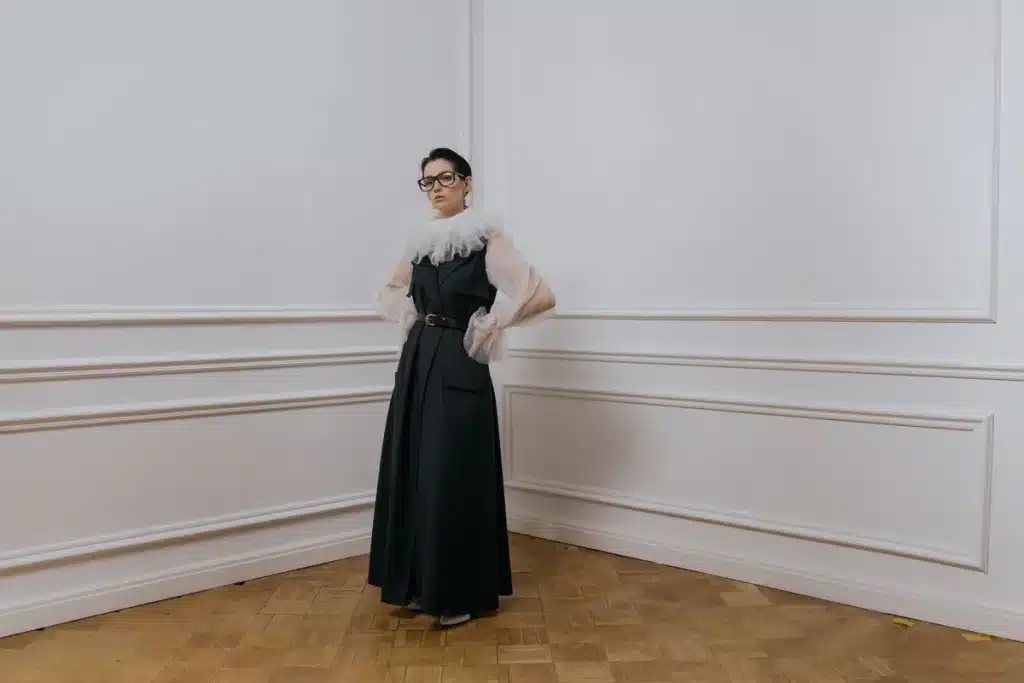Femme en costume épuré et accessoires structurés, palette neutre, posture formelle