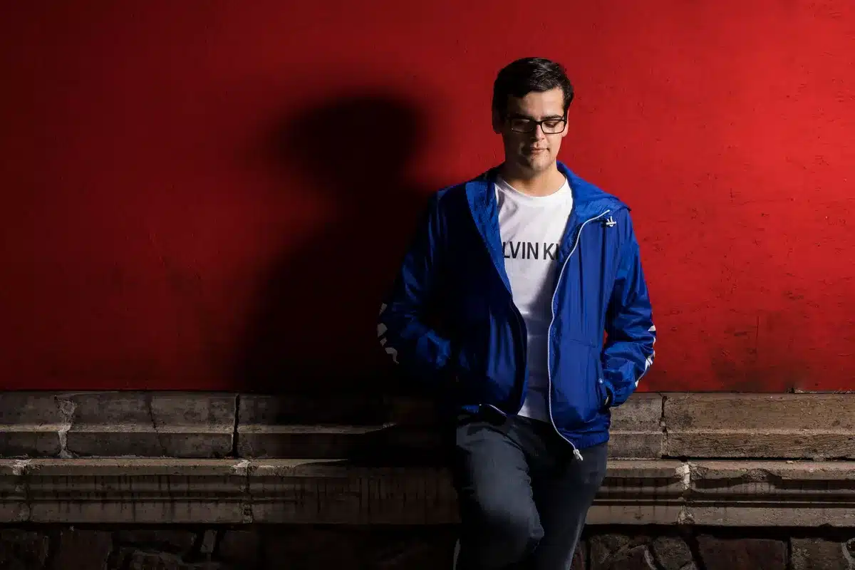 Silhouette d'une figure vêtue d'un blouson Teddy rouge et d'un jean brut, incarnant l'esthétique visuelle du personnage