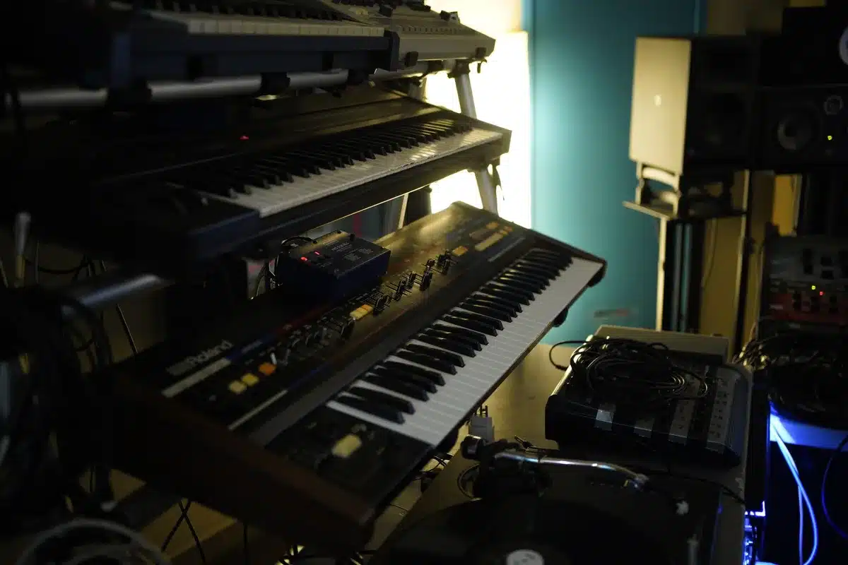 Équipement de studio de musique électronique rétro avec synthétiseurs et matériel audio professionnel.