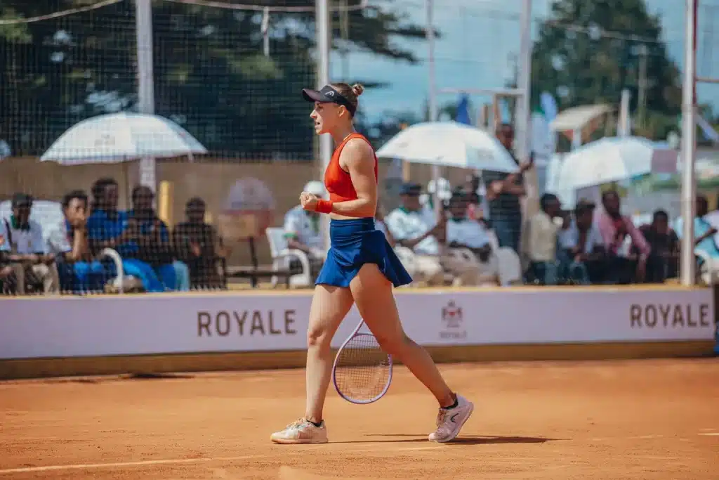 Femme vêtue d'une tenue tennis blanche et de lunettes de soleil lors d'une cérémonie formelle