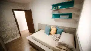 Chambre d'enfant aménagée avec mobilier modulable, rangements intégrés et étagères ouvertes optimisant l'espace