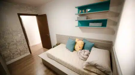 Chambre d'enfant aménagée avec mobilier modulable, rangements intégrés et étagères ouvertes optimisant l'espace