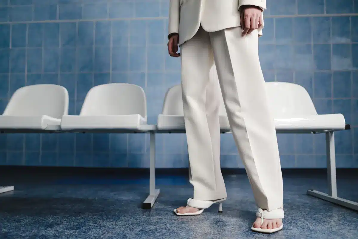 Tenue estivale composée d'un pantalon blanc en lin structuré avec une veste colorée et accessoires minimalistes.