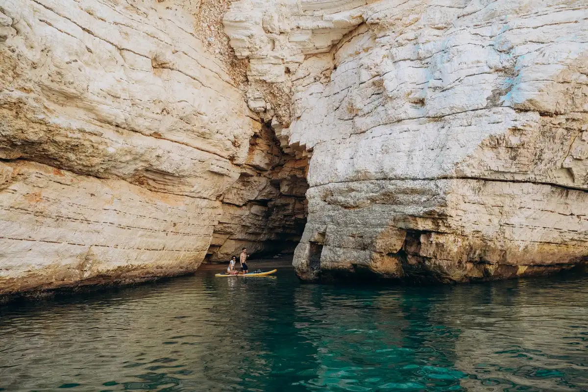 Falaises calcaires plongeant dans une eau turquoise méditerranéenne.
