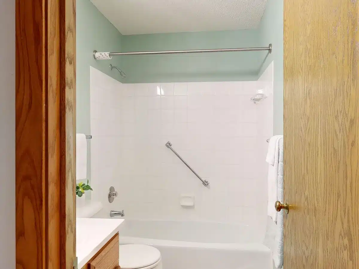 Salle de bain adaptée aux seniors avec barres d'appui, sol antidérapant et douche accessible