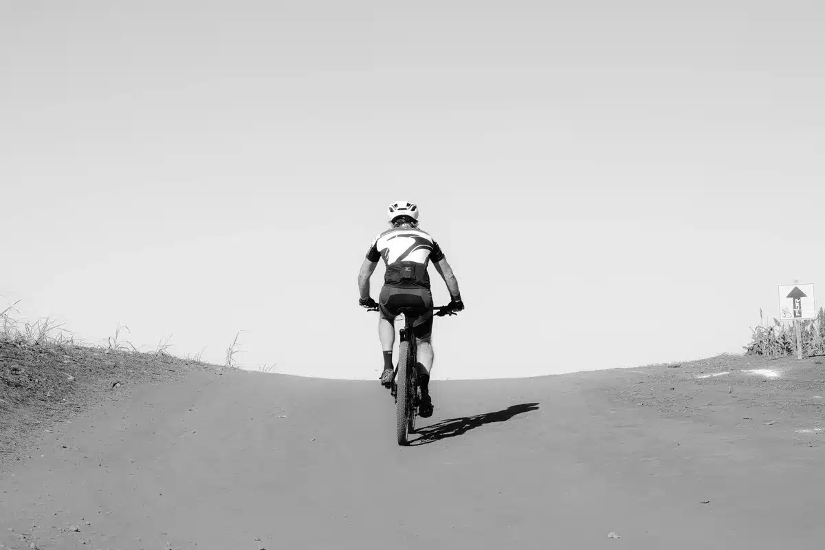 Coureuse cycliste en montée sur un terrain vallonné, spécialiste des bosses.