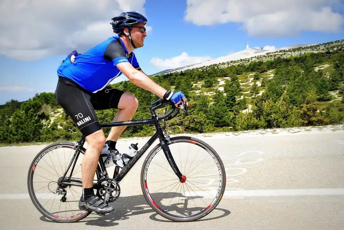Cycliste en échappée solitaire sur un profil montagneux, maintenant son avance