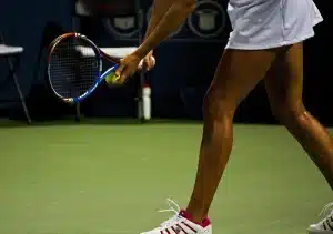 Joueur de tennis en plein service sur court dur, en position de force