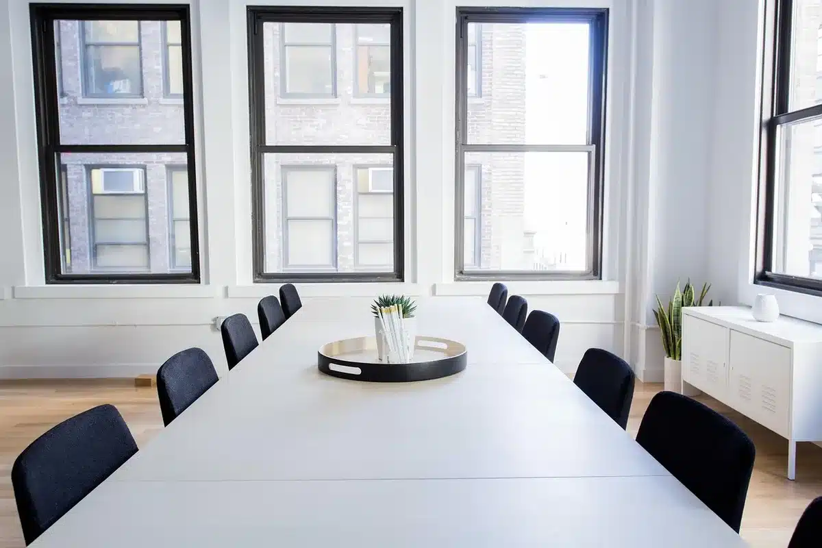 Réunion administrative autour d'une table de conférence dans une salle officielle