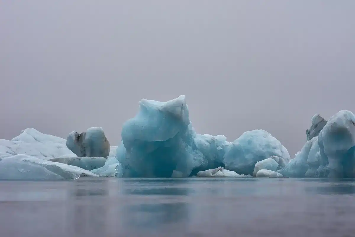 Surface glaciaire sombre exposée et zones de neige clairsemée au printemps