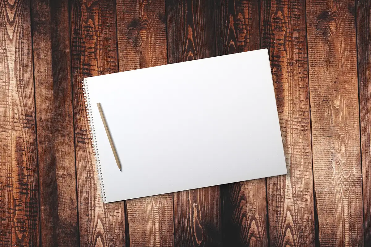 Classeur à onglets à côté d'un ordinateur portable sur une table baignée de lumière
