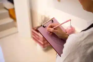 Maison, documents et chantiers: organisez tout pour éviter surprises et gagner du temps Table de jour avec classeur ouvert, tablette et mains organisant des documents