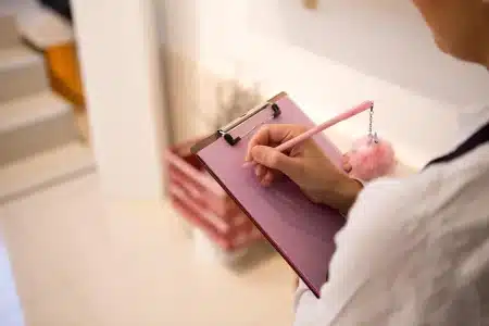 Table de jour avec classeur ouvert, tablette et mains organisant des documents