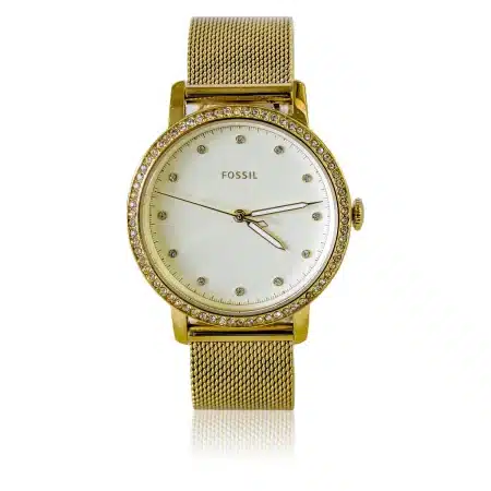 Poignet anonyme portant une montre ovale près d'une robe en satin et d'une minaudière