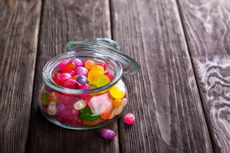 Mains vidant une coupelle d'eau stagnante sous un pot de fleur sur une terrasse ensoleillée