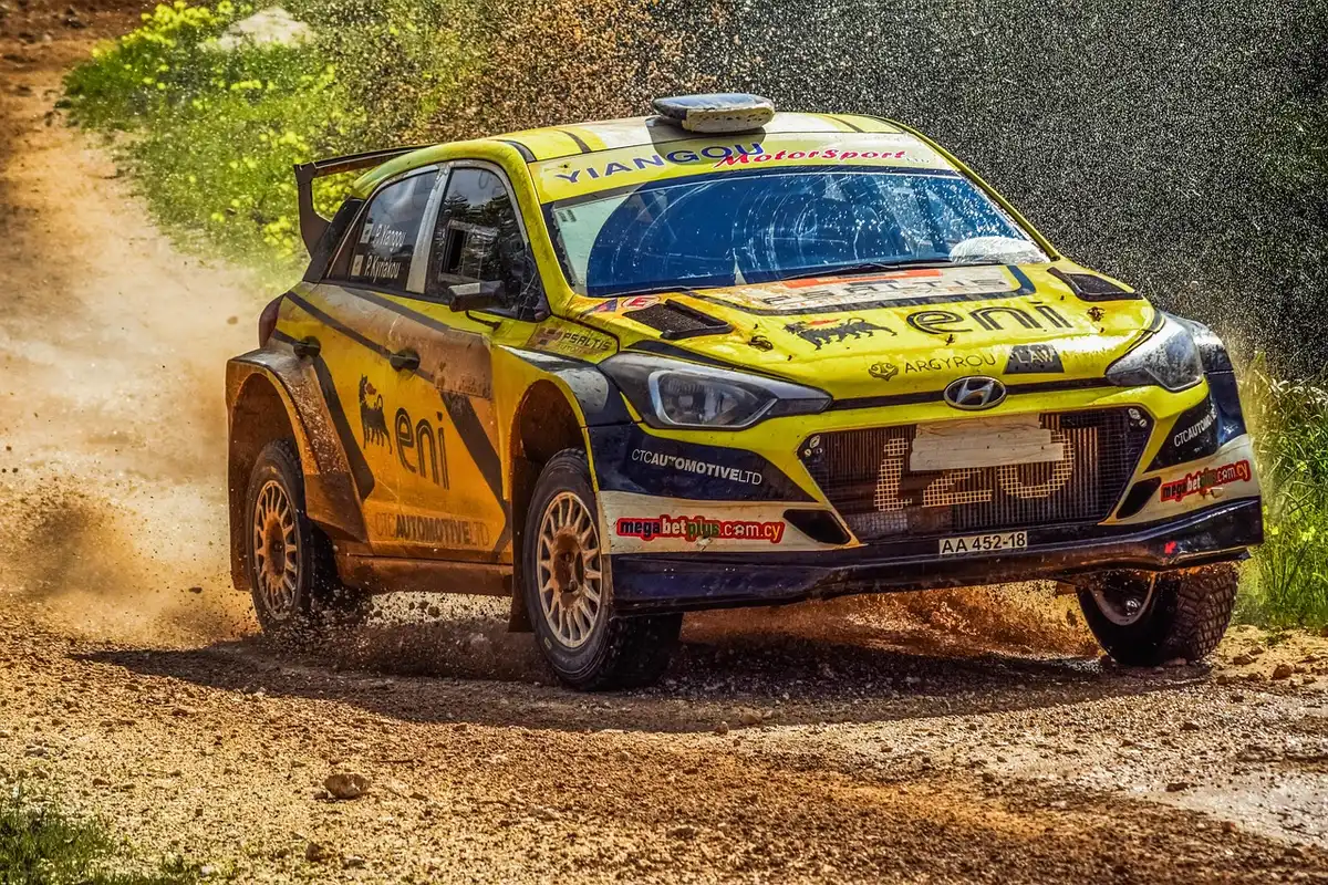 Equipe de rallye travaillant sur une voiture dans l'aire de service en pleine journée