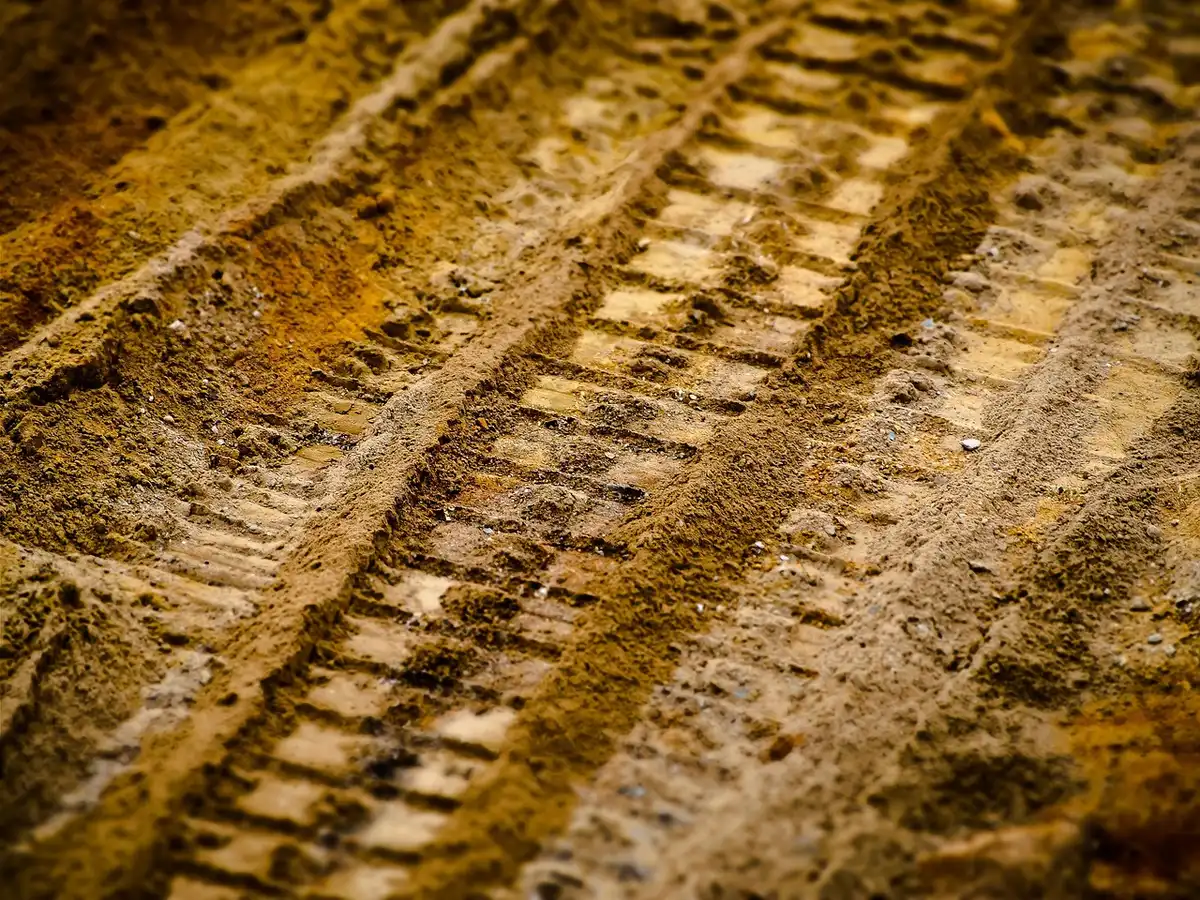 Piste de rallye sèche et poussiéreuse sous le soleil, abrasivité visible