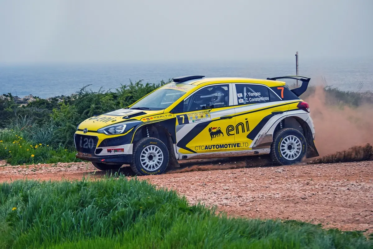 Voiture de rallye dépassant une autre sur une piste de terre en plein jour