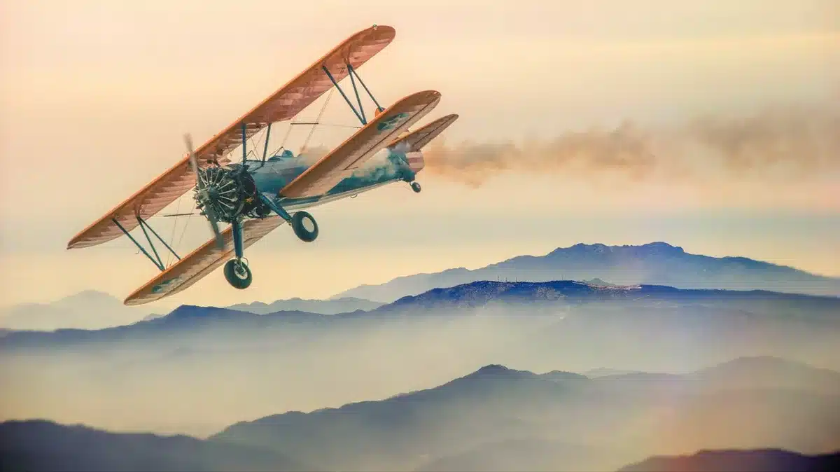 Un petit avion survolant un paysage montagneux et spectaculaire sous un ciel dégagé