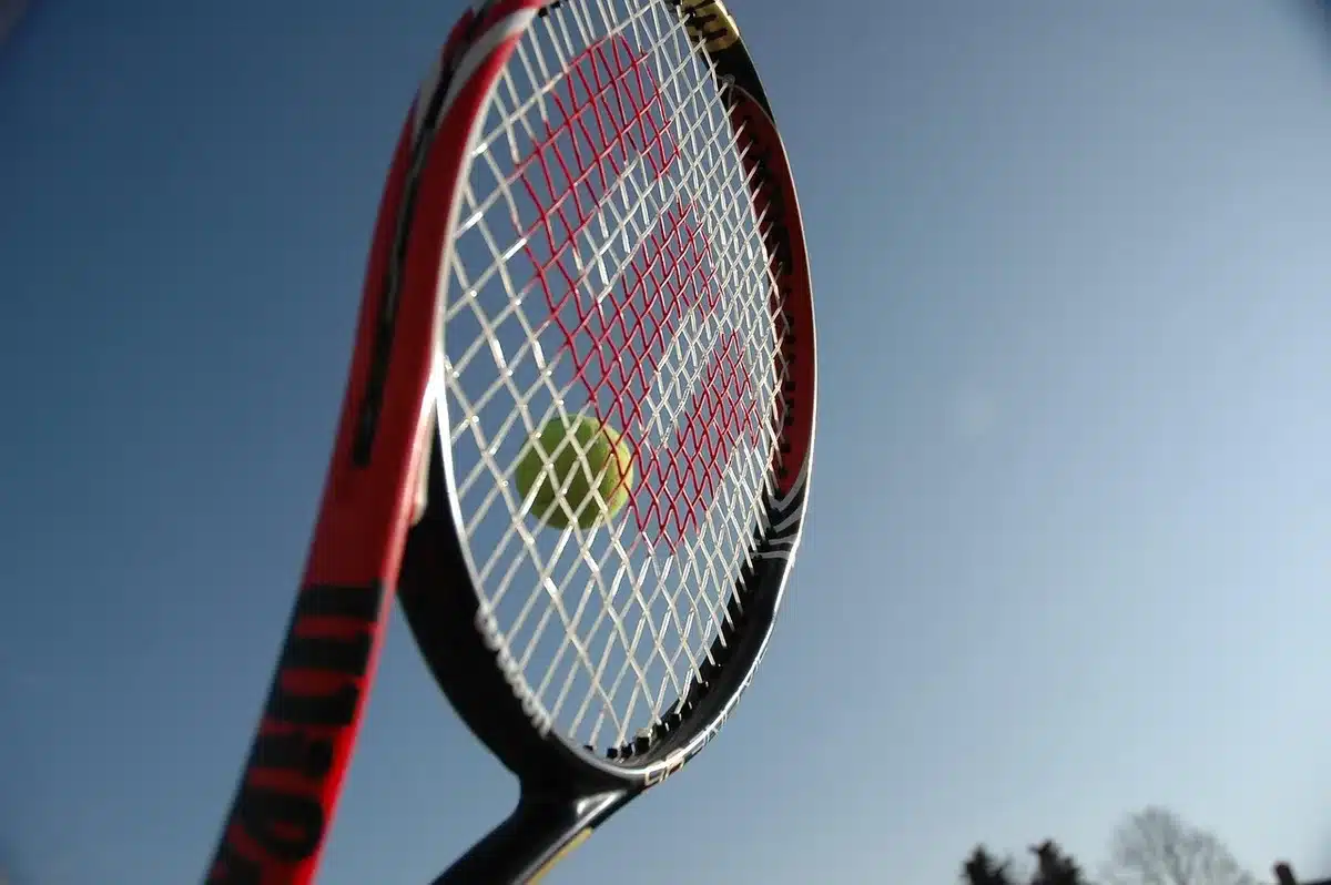 Moment décisif d'un super tie-break en finale de tennis, avec les joueurs concentrés au filet.