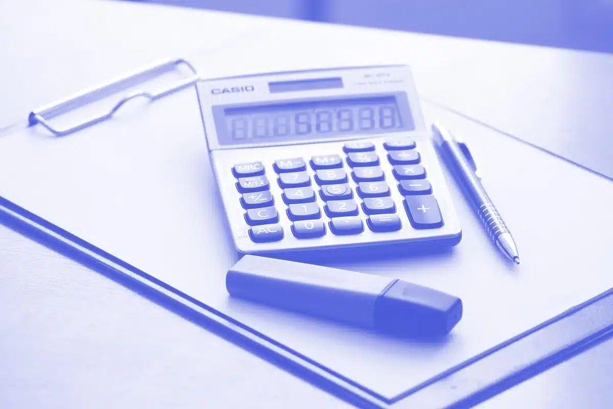 Documents agricoles et calculatrice sur un bureau pour préparer une demande d'aide