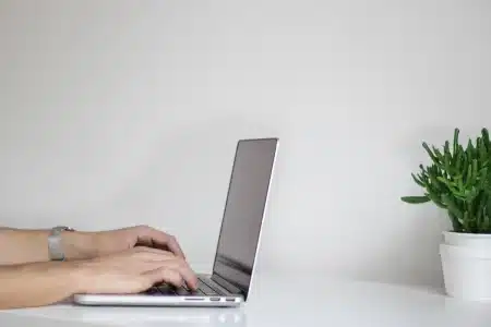 Mains anonymes consultant une carte marine et un ordinateur portable sur un quai en pleine journée
