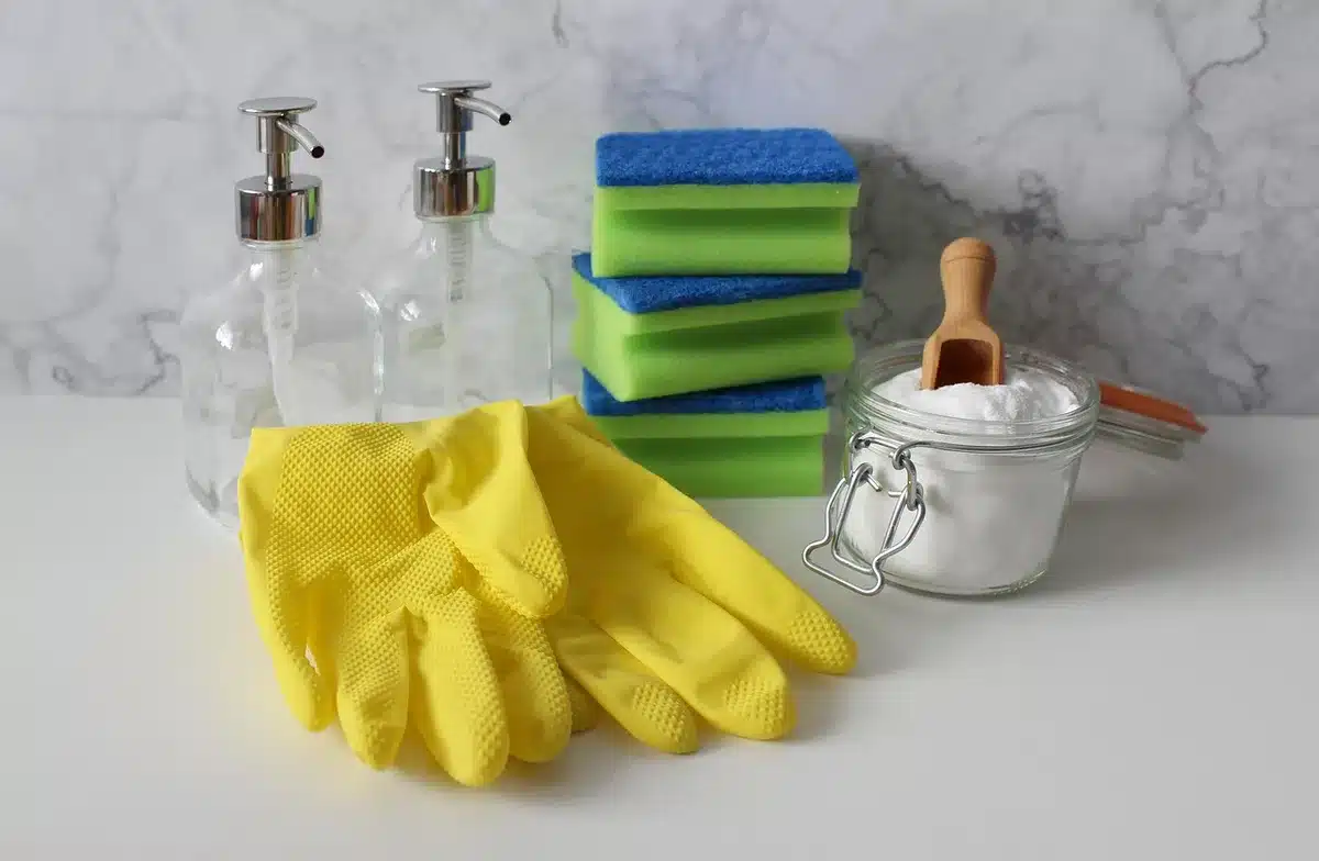 Nettoyage manuel de baskets en cuir avec une éponge et une brosse près d'une fenêtre