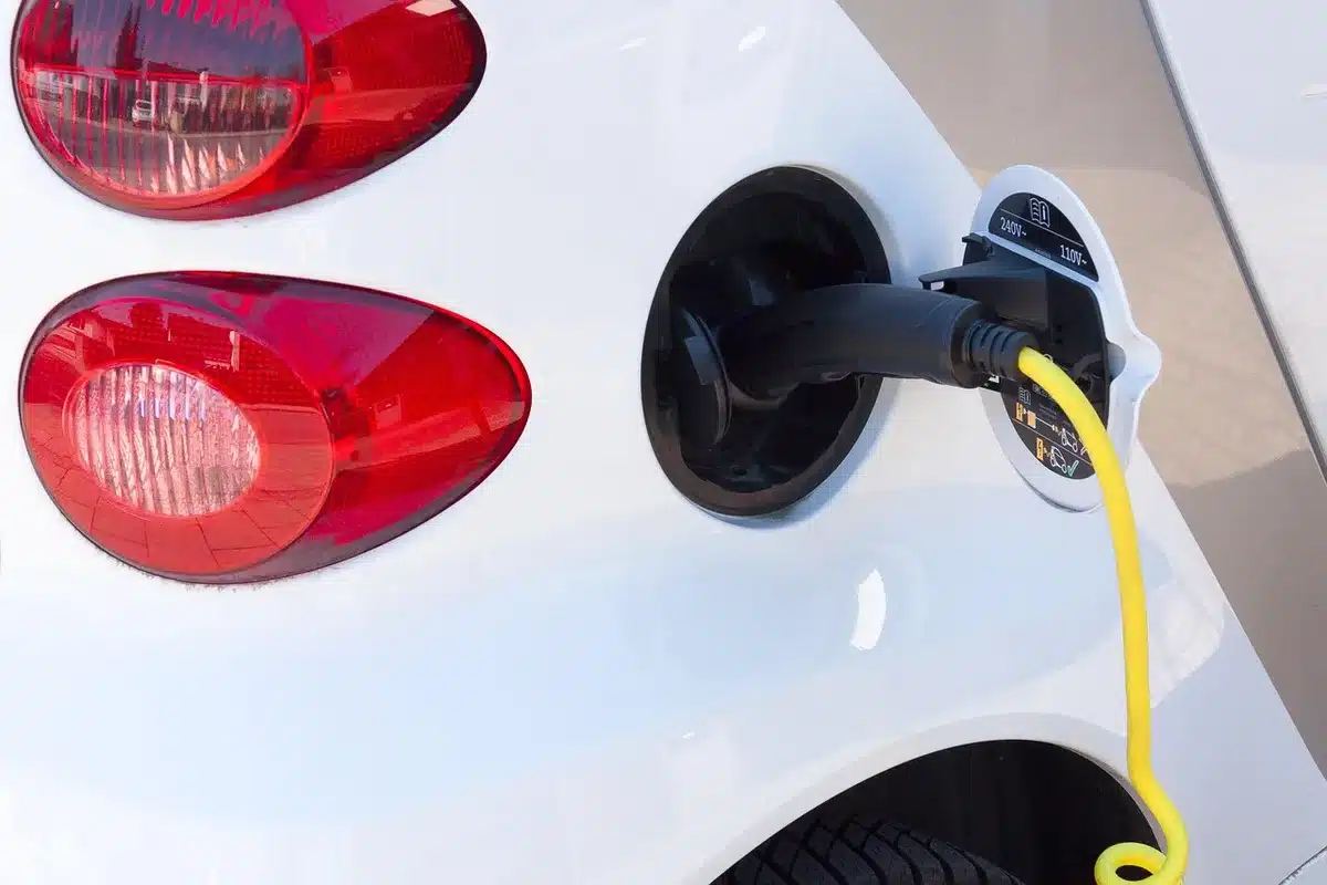 Voiture électrique branchée devant une maison, prêt pour une charge nocturne