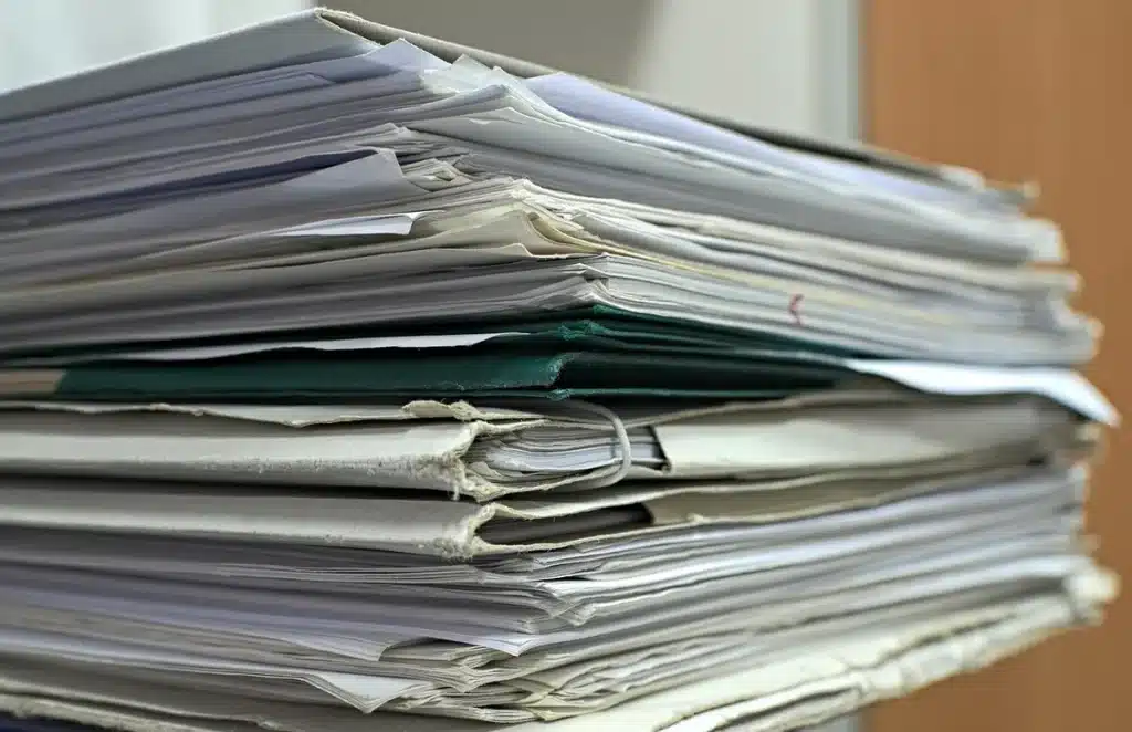 Documentations et mains au comptoir d'une mairie près d'un lac en journée