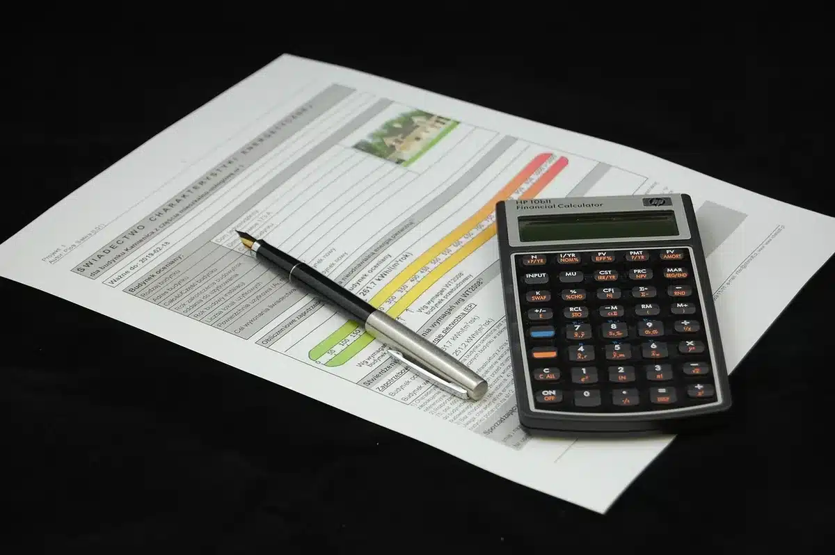 Documents financiers et calculatrice sur un bureau illustrant le coût de 33,36 milliards d'euros