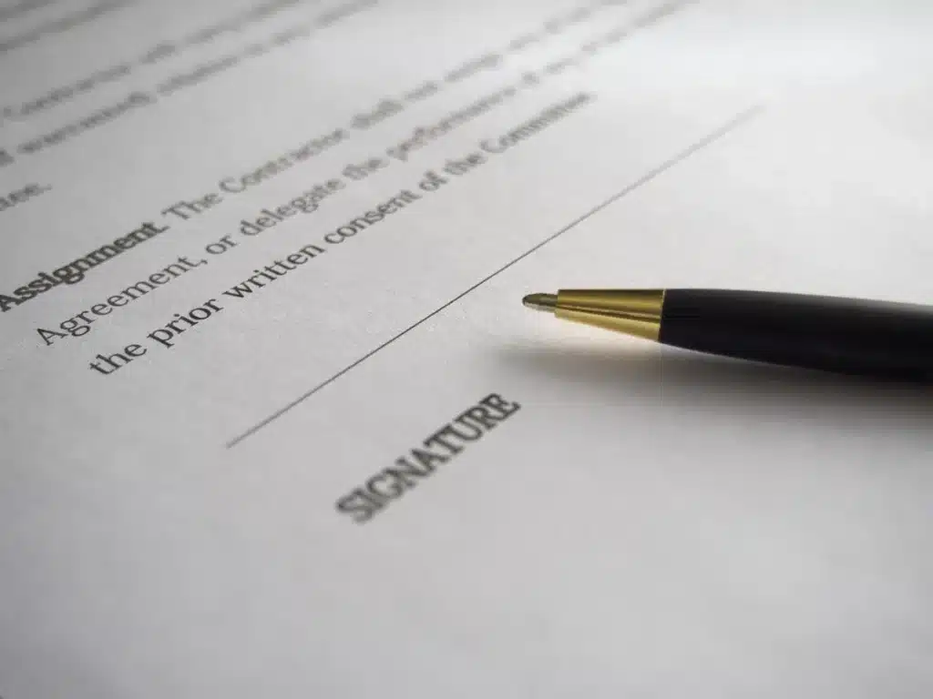 Salle de réunion d'une rédaction en plein jour, mains anonymes feuilletant des documents