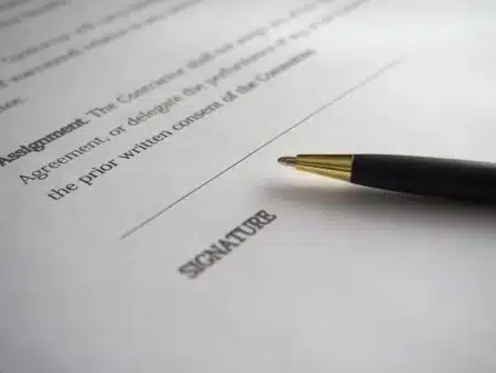 Salle de réunion d'une rédaction en plein jour, mains anonymes feuilletant des documents