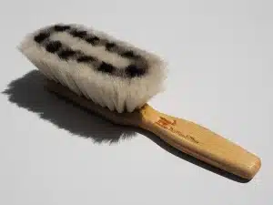 Nettoyage de chaussures en suède sur une table près d'une fenêtre, lumière du jour