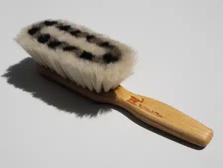 Nettoyage de chaussures en suède sur une table près d'une fenêtre, lumière du jour