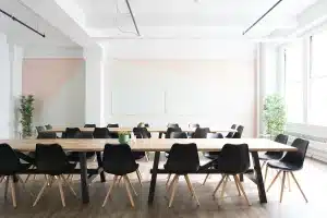 Table de réunion en journée avec documents politiques et mains anonymes pointant vers une carte