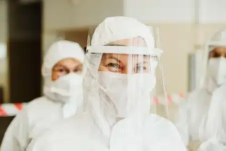 Bureau médical en plein jour, mains anonymes feuilletant des dossiers professionnels