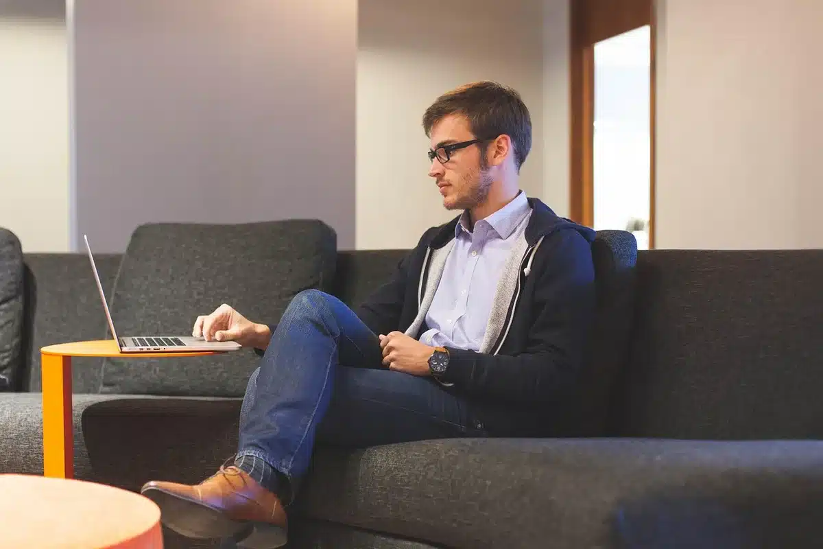 Mains tapant sur un ordinateur portable près de documents, lumière du jour