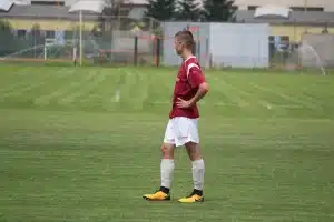 Bords du terrain de football en plein jour avec un tableau de notes et un ballon flou en arrière-plan