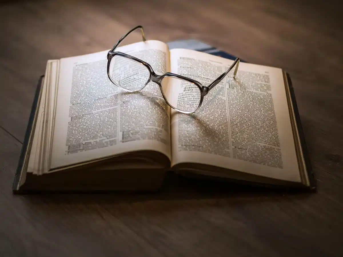 Gros plan sur un livre papier et des mains tournant une page, montrant l'expérience tactile