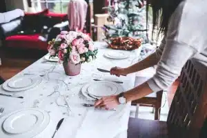 Mains posées sur une table ensoleillée près d'une petite boîte à bijoux ouverte