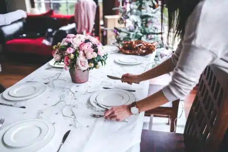 Mains posées sur une table ensoleillée près d'une petite boîte à bijoux ouverte
